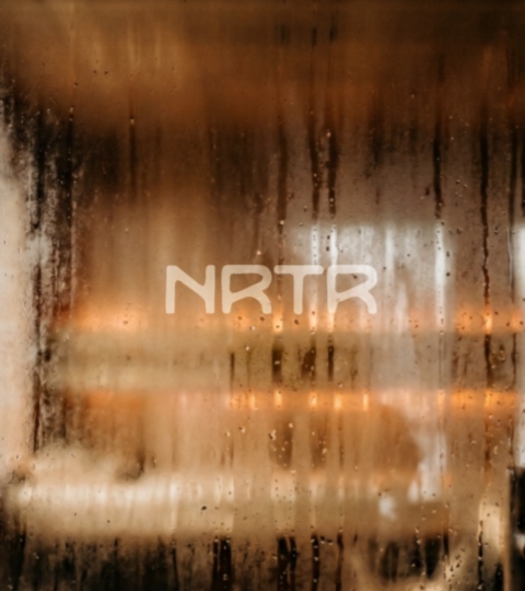 Visualization — warm light through steam-fogged glass, the NRTR mark just visible